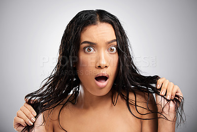 Buy stock photo Cropped portrait of an attractive young woman looking shocked in studio against a grey background