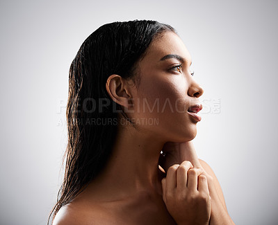 Buy stock photo Cropped shot of an attractive young woman looking thoughtful while posing in studio against a grey background