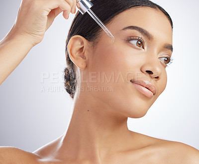 Buy stock photo Skincare, face and girl with essential oil in studio for wellness, dermatology and hyaluronic acid application on grey background. Vitamin C, beauty and model with face serum, facial or retinol drip