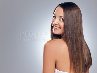 Buy stock photo Shot of an attractive young woman standing alone in the studio and looking over her shoulder