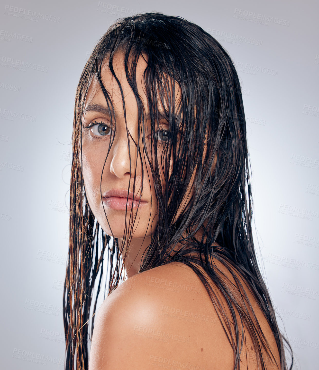 Buy stock photo Shot of an attractive young woman standing alone in the studio and posing with wet hair