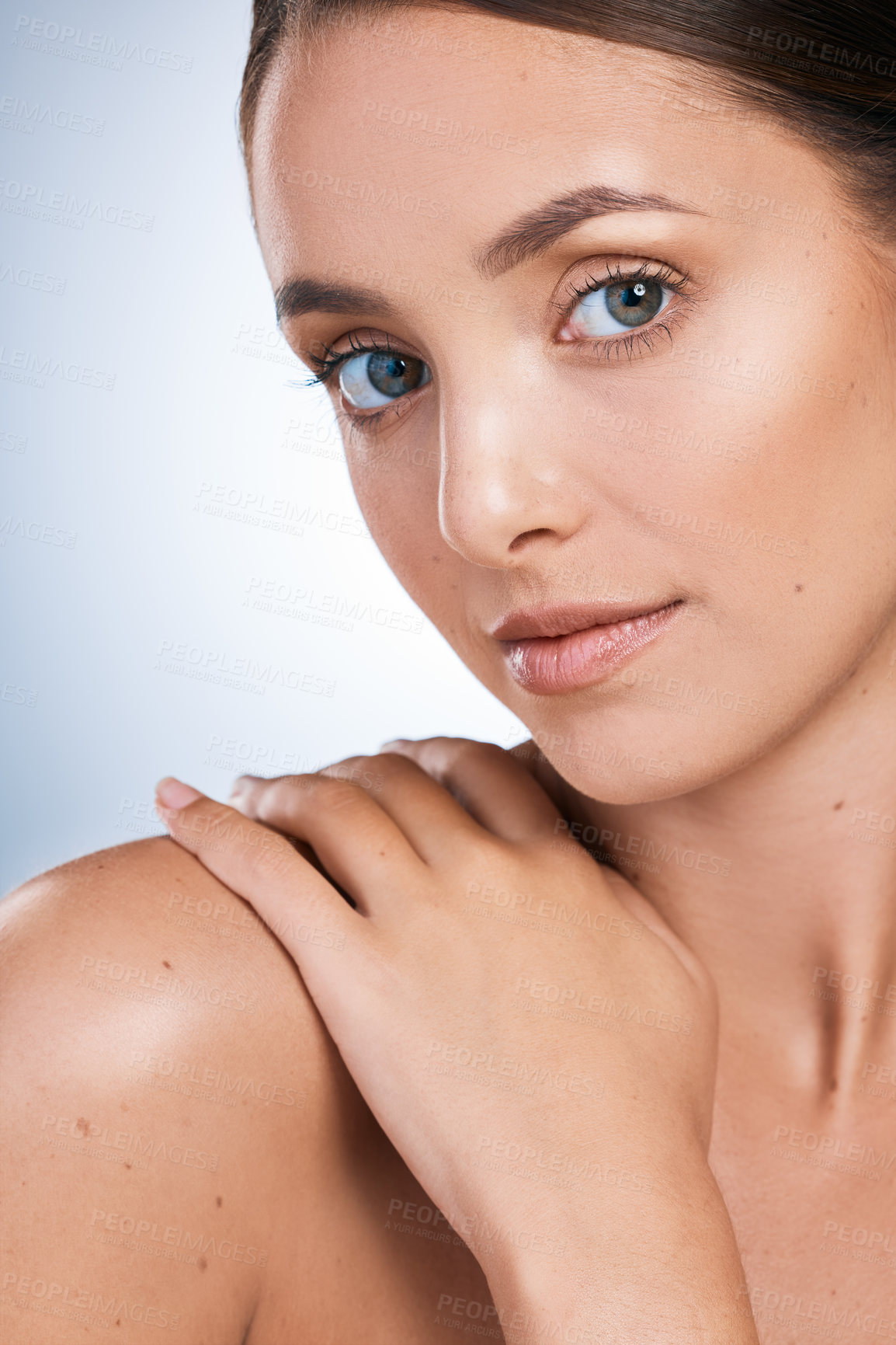 Buy stock photo Closeup portrait of a beautiful young woman posing against a blue background