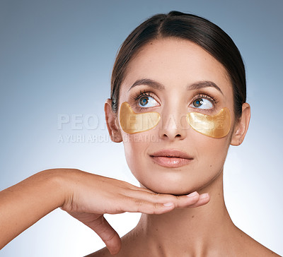 Buy stock photo Shot of a young attractive woman wearing an under eye patch against a blue background