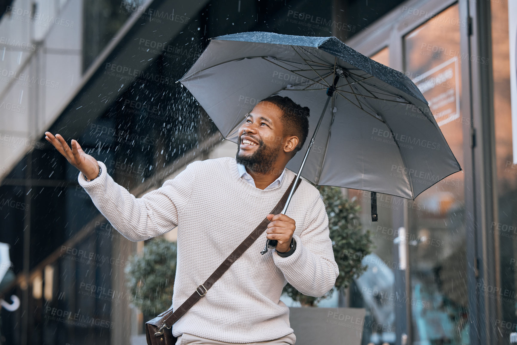 Buy stock photo Rain, walking and black man in city with smile, happiness and travel to work in London. Hand, business person and umbrella for protection, enjoy water drops and winter weather while commute in street