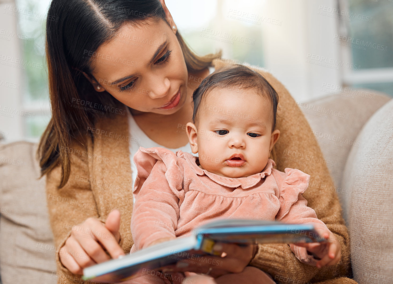 Buy stock photo Shot of a woman reading to her baby girl
