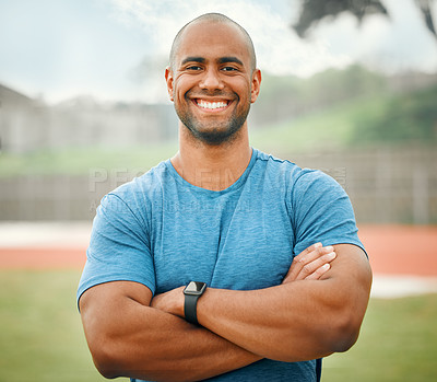 Buy stock photo Cropped portrait of a handsome young male athlete standing outside with his arms folded