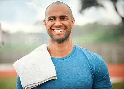 Buy stock photo Cropped portrait of a handsome young male athlete standing outside with a towel over his shoulder