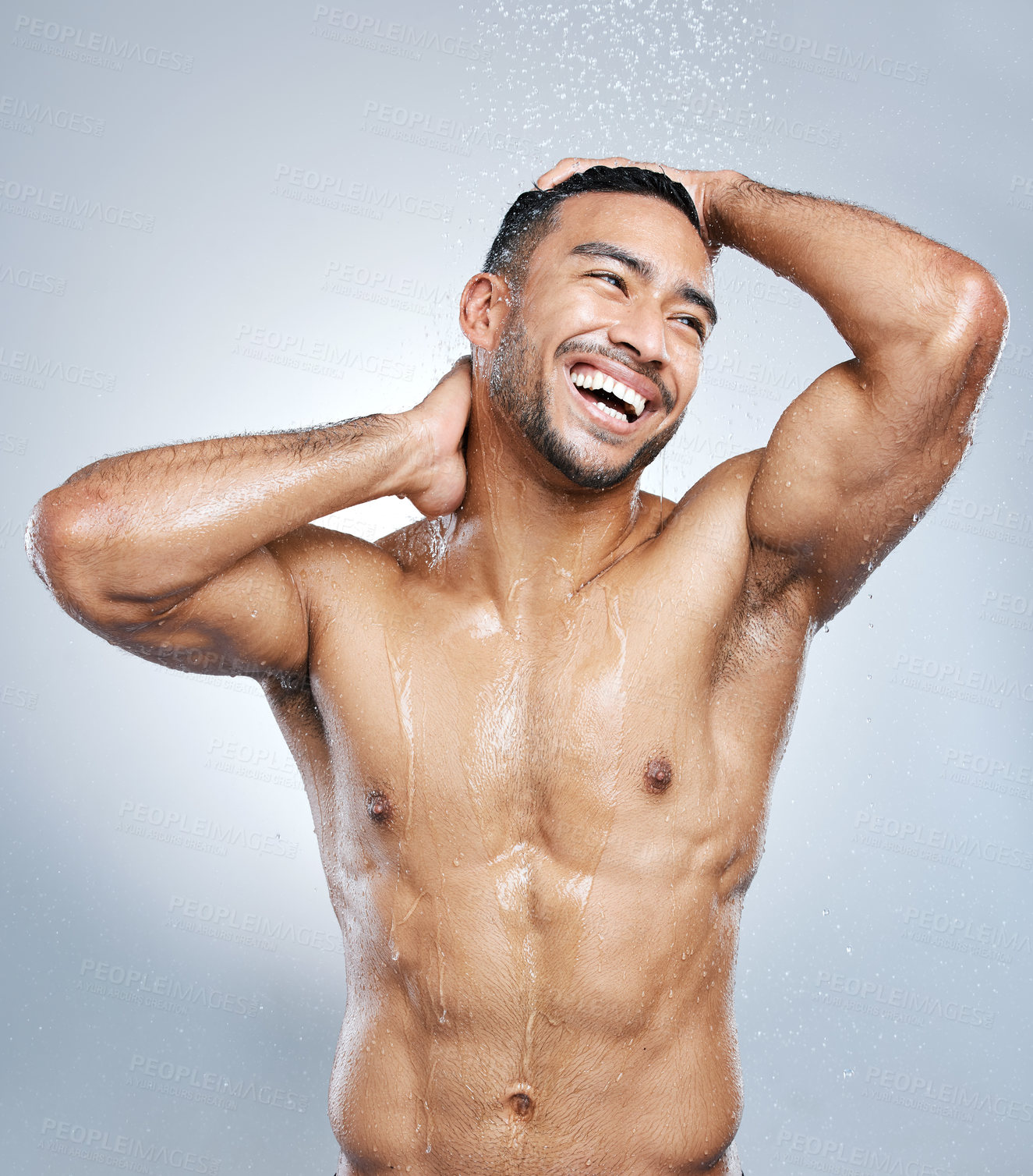 Buy stock photo Studio shot of a handsome young man taking a shower against a grey background