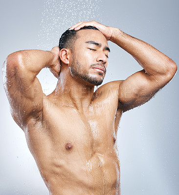 Buy stock photo Man in shower with blue background, cleaning and skincare for hygiene with shampoo, healthy body and studio backdrop. Water, skin and hair care, male model washing in bathroom spa with self love.