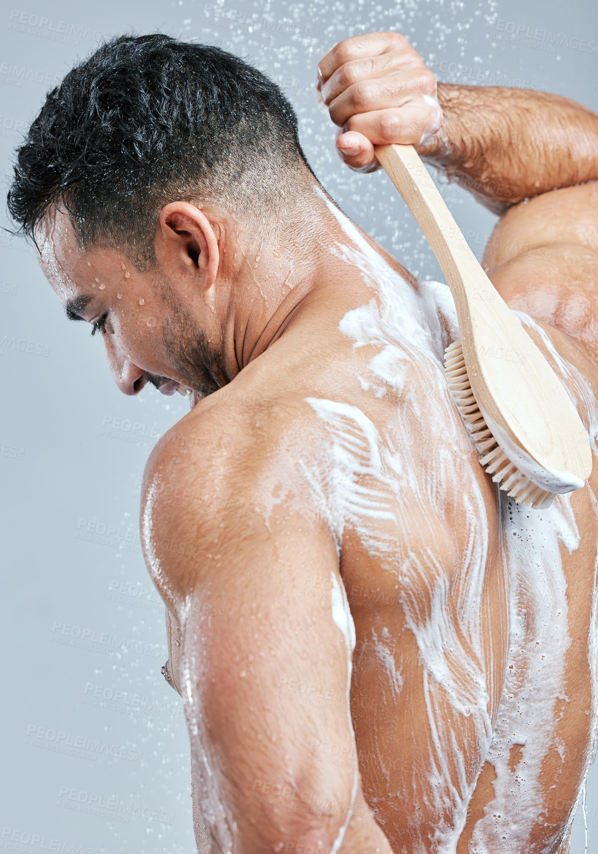 Buy stock photo Brush, man and washing back for hygiene, grooming and self care or cleaning in studio grey background. Wellness, male person and water with foam soap showering for body health and feeling fresh