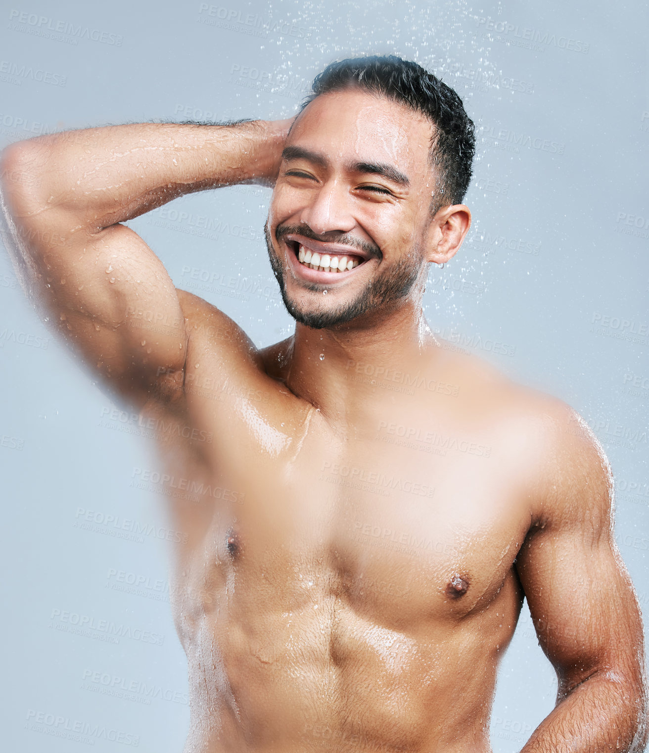 Buy stock photo Studio shot of a handsome young man taking a shower against a grey background