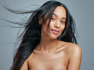 Buy stock photo Studio portrait of an attractive young woman posing against a grey background