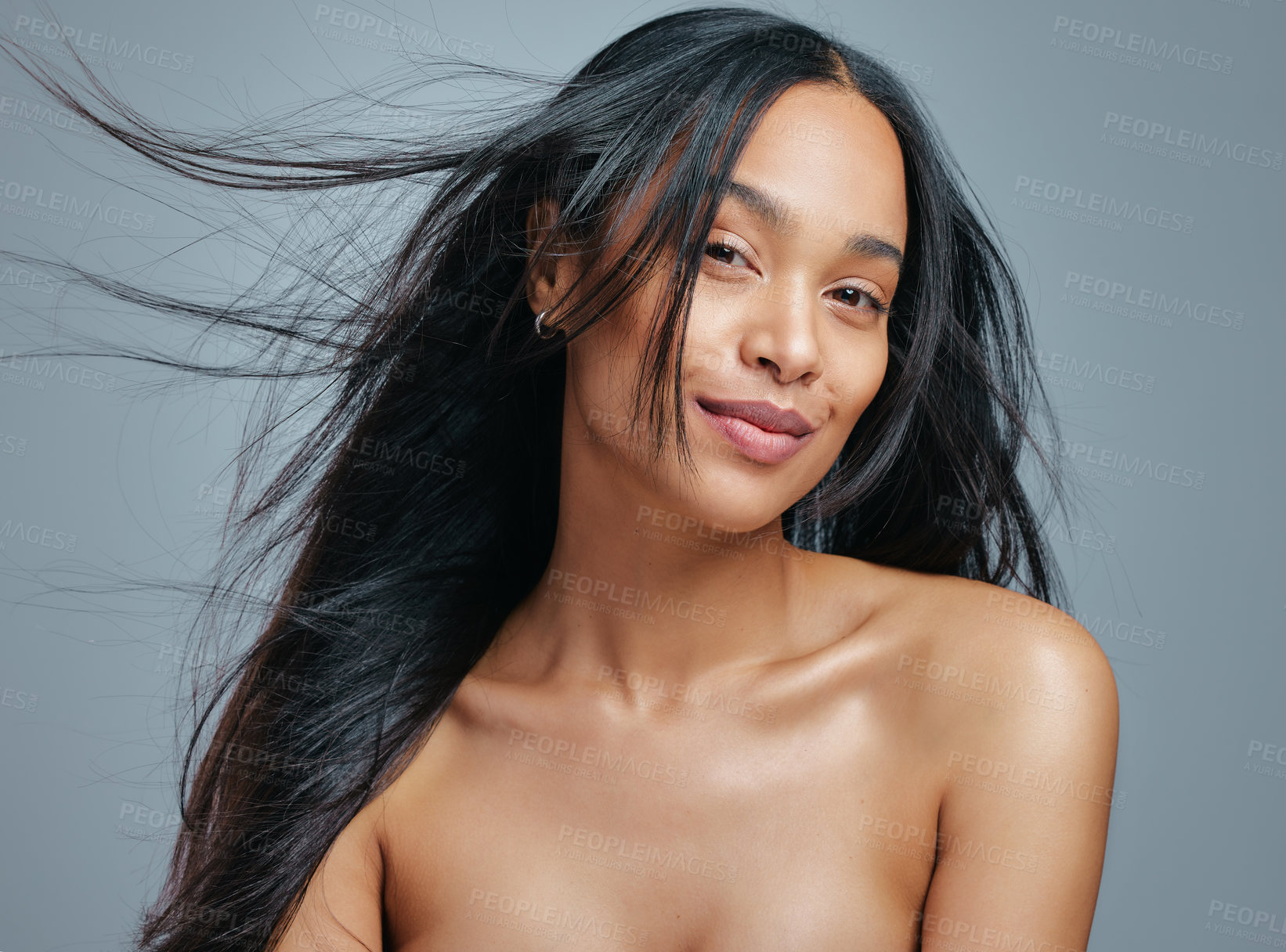 Buy stock photo Studio portrait of an attractive young woman posing against a grey background