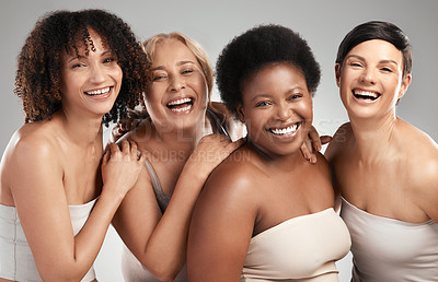 Buy stock photo Shot of a diverse group of women standing and hugging each other in the studio