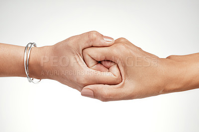 Buy stock photo Cropped shot of two unrecognizable women interlocking their hands in the studio