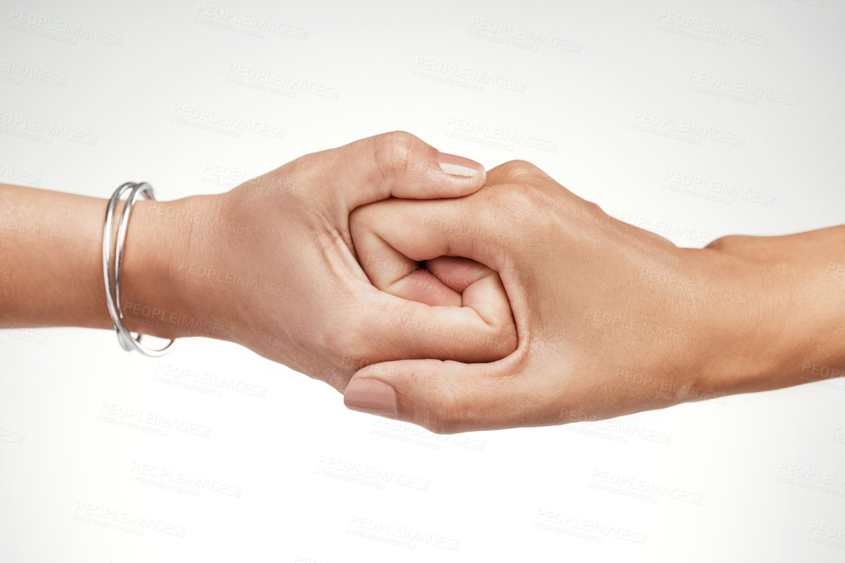Buy stock photo Cropped shot of two unrecognizable women interlocking their hands in the studio
