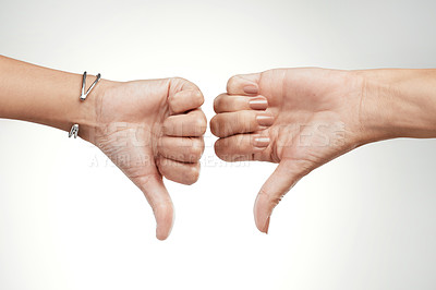 Buy stock photo Cropped shot of two unrecognizable women showing a thumbs down in the studio