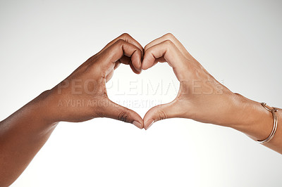 Buy stock photo Cropped shot of two unrecognizable women making a heart-shaped gesture in the studio