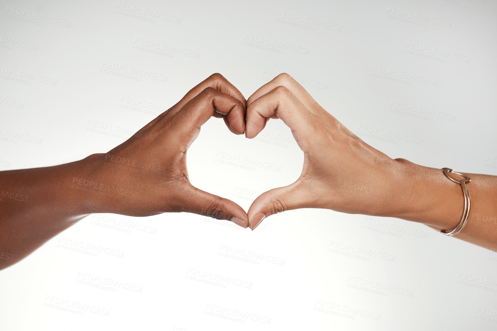 Buy stock photo Cropped shot of two unrecognizable women making a heart-shaped gesture in the studio