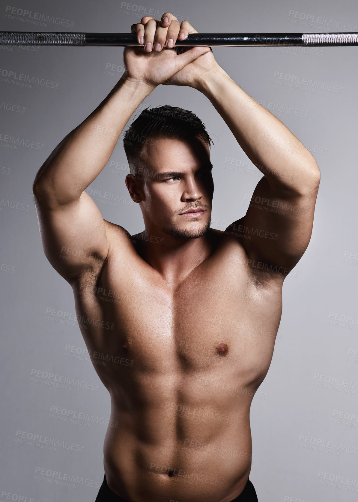 Buy stock photo Studio shot of a muscular young man posing against a grey background