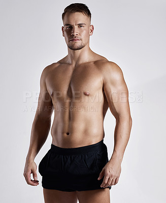 Buy stock photo Shot of a muscular young man posing against a white background