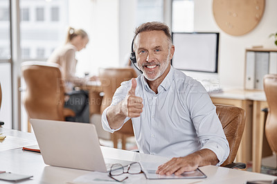Buy stock photo Shot of a mature man using a headset and showing thumbs up in a modern office