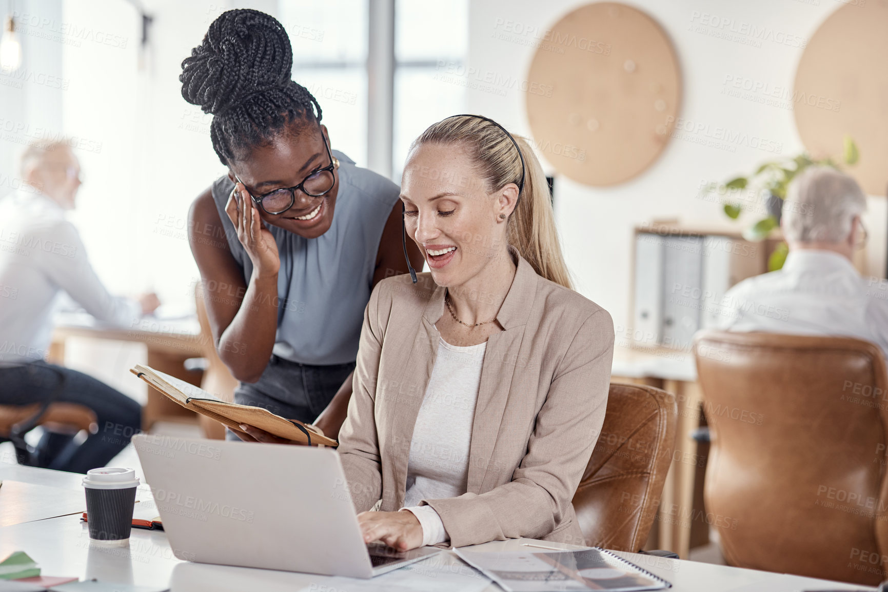 Buy stock photo Shot of two young women using headsets and laptop in a modern office