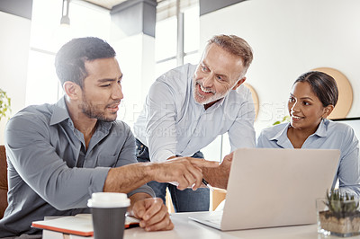 Buy stock photo Shot of a group of businesspeople using a laptop in a modern office