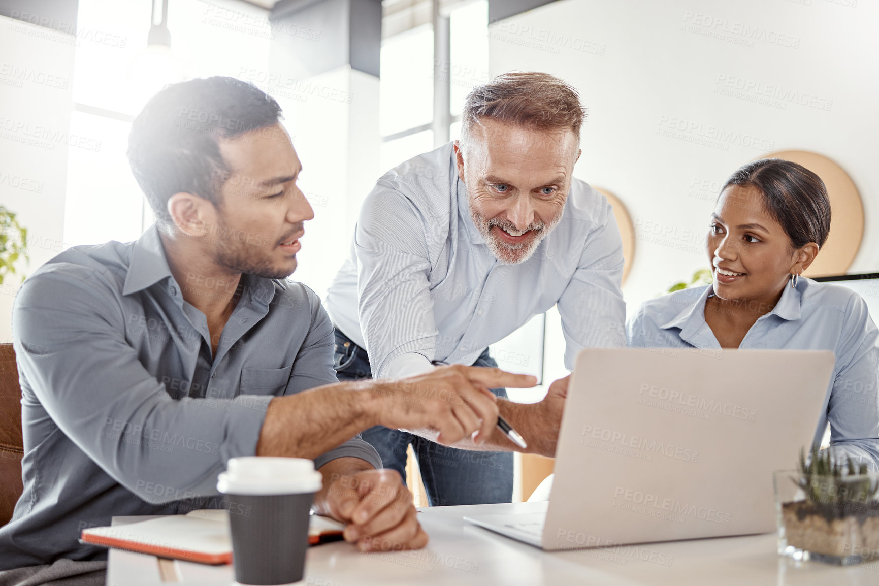 Buy stock photo Shot of a group of businesspeople using a laptop in a modern office