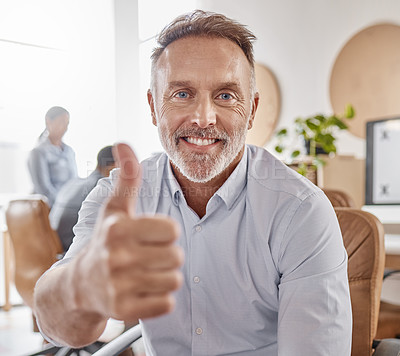 Buy stock photo Portrait of a mature businessman showing thumbs up in a modern office