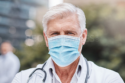 Buy stock photo Shot of a mature male doctor standing in the city