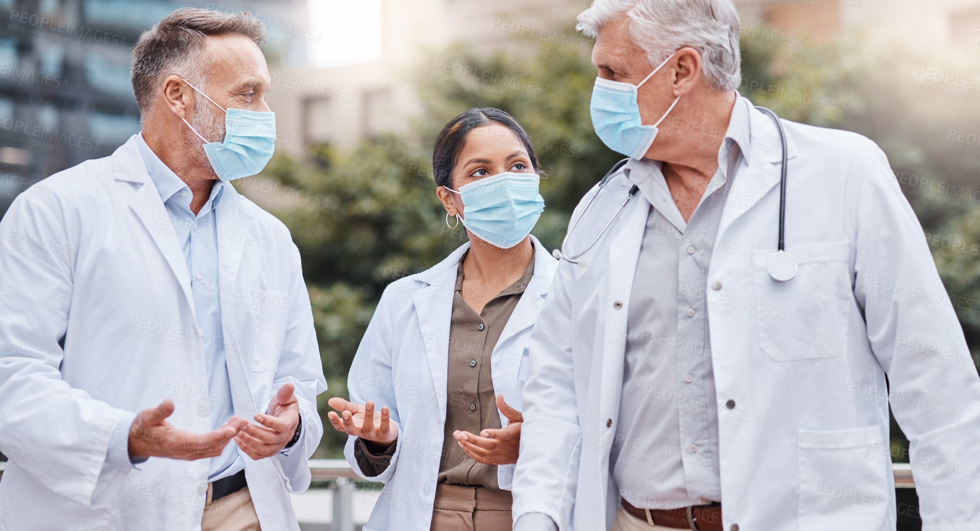 Buy stock photo Shot of a group of doctors talking in the city