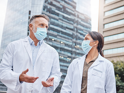 Buy stock photo Shot of two doctors talking in the city