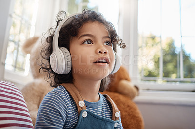 Buy stock photo Shot of an adorable young boy using headphones in his bedroom at home