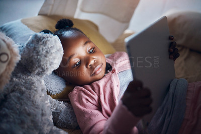 Buy stock photo Shot of a little girl using her digital tablet in her bedroom