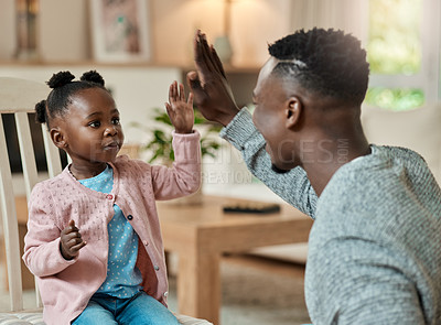 Buy stock photo Cropped shot of an adorable little girl high fiving her dad in the living room at home