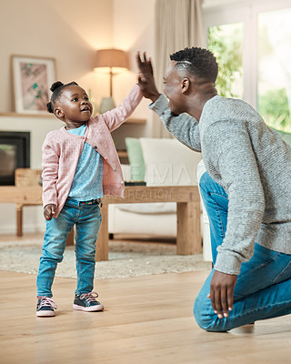 Buy stock photo Full length shot of an adorable little girl high fiving her dad in the living room at home