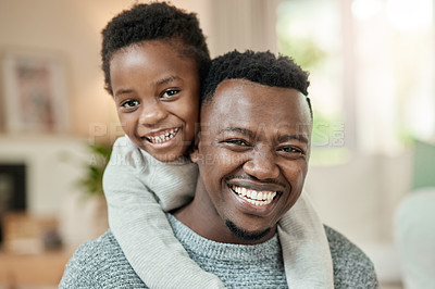 Buy stock photo Cropped portrait of a handsome young man piggybacking his son in the living room at home