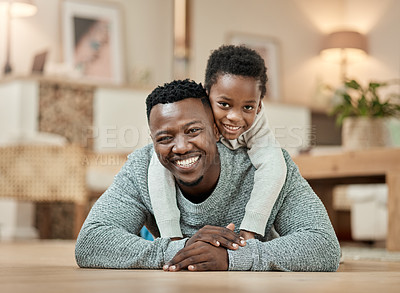 Buy stock photo Full length portrait of a handsome young man and his son lying on the living room floor at home