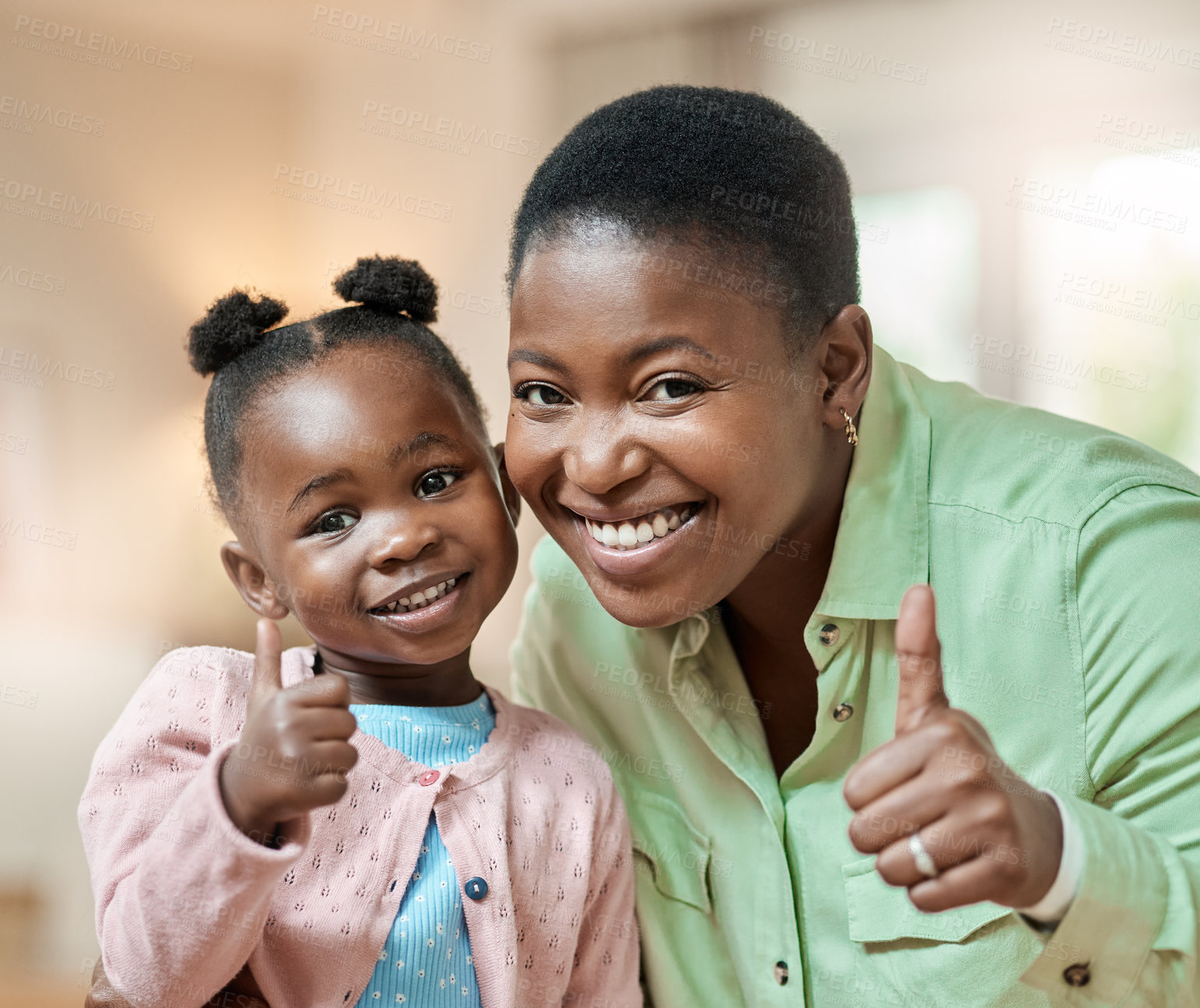 Buy stock photo Cropped portrait of an attractive young woman and her daughter giving thumbs up in the living room at home