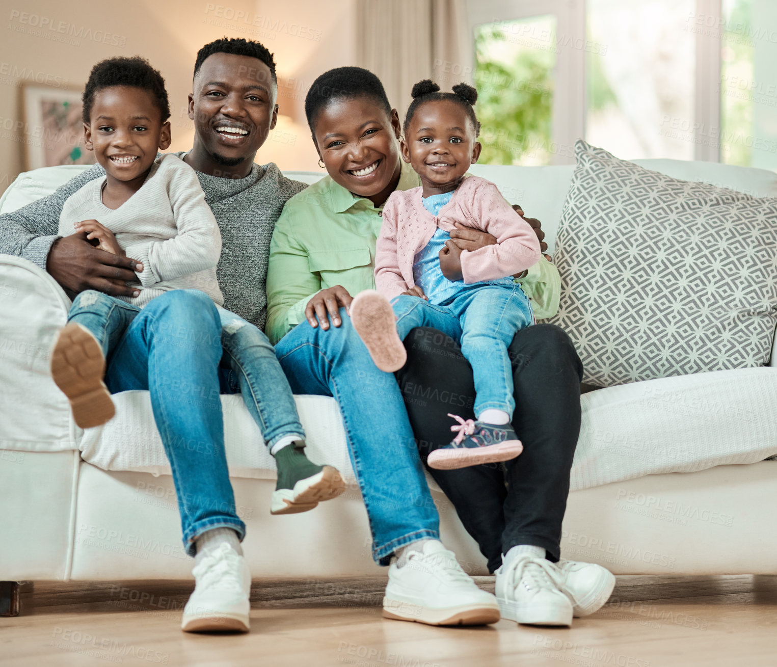 Buy stock photo Full length shot of an affectionate young family of four sitting on their sofa in the living room at home