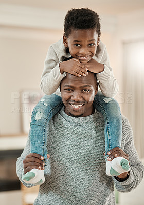 Buy stock photo Cropped portrait of a handsome young man carrying his son on his shoulders in the living room at home