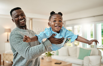 Buy stock photo Cropped portrait of a handsome young man lifting is daughter high up in the air while playing in the living room at home