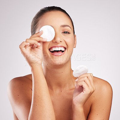 Buy stock photo Shot of an attractive young woman wiping her face with cotton against a studio background