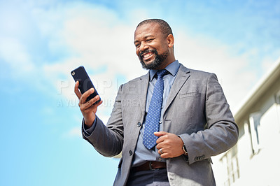 Buy stock photo Shot of a businessman using his cellphone while out in the city