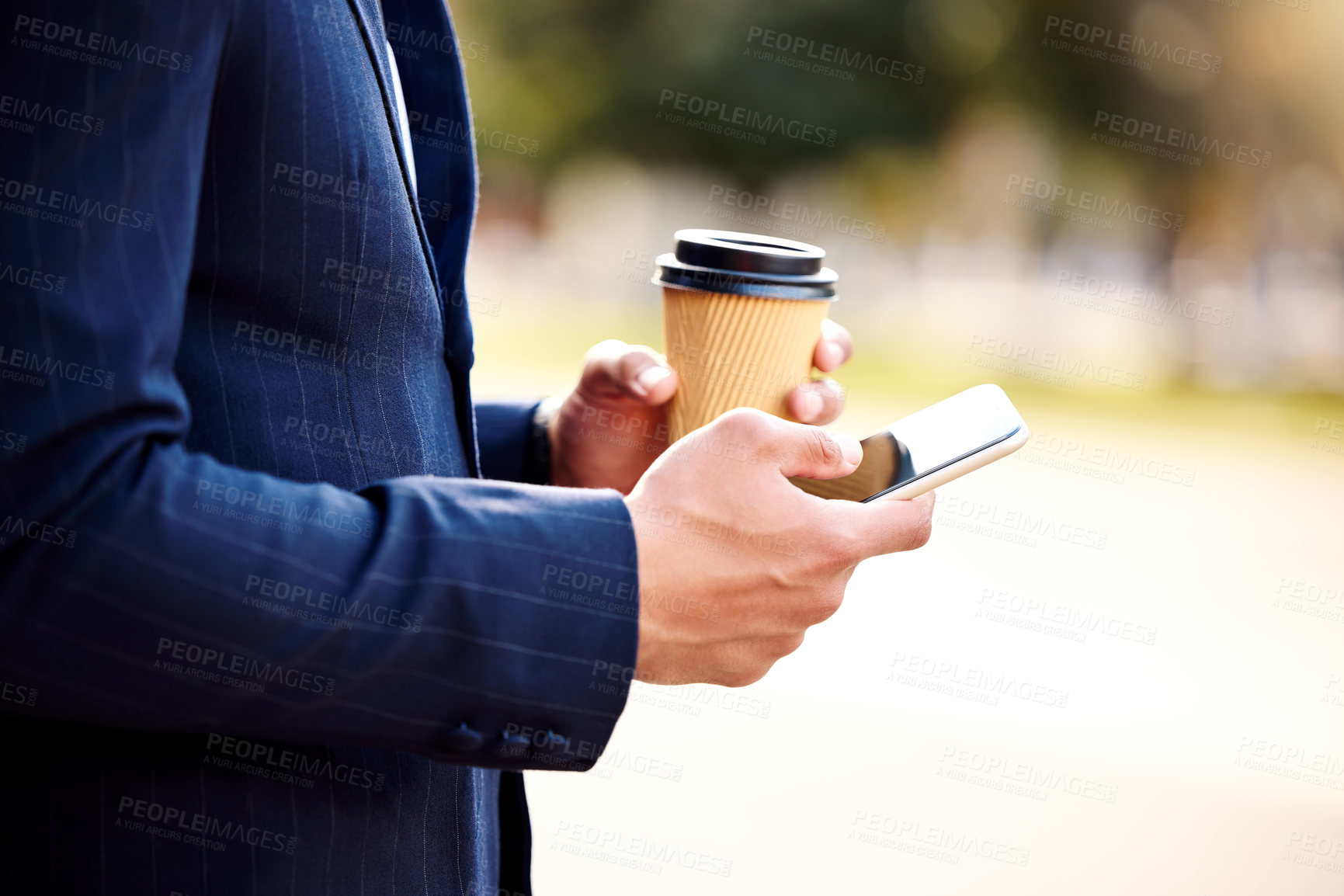 Buy stock photo Shot of a businessman using his smartphone while drinking coffee