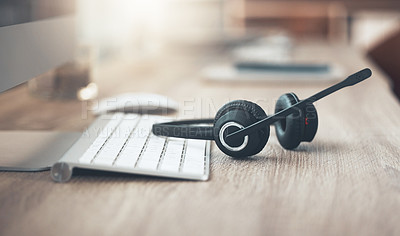 Buy stock photo Shot of a pair of headsets lying on the desk in an empty office