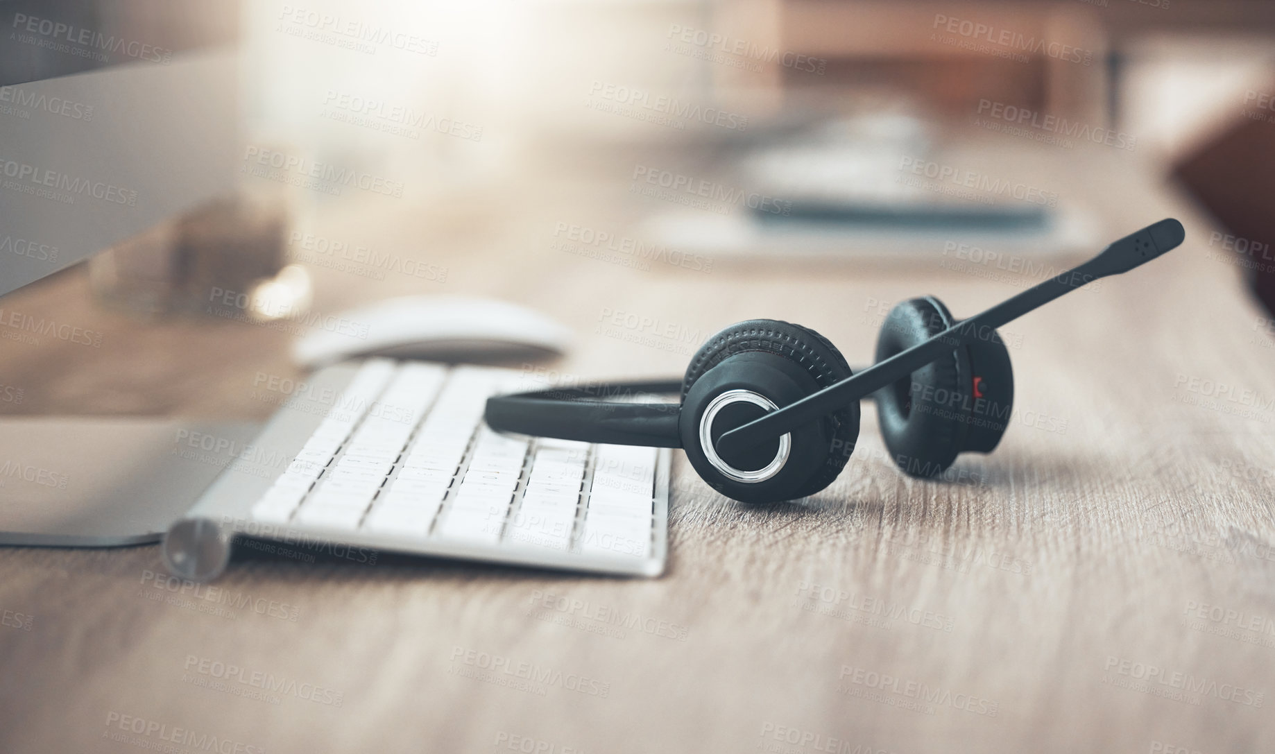Buy stock photo Shot of a pair of headsets lying on the desk in an empty office