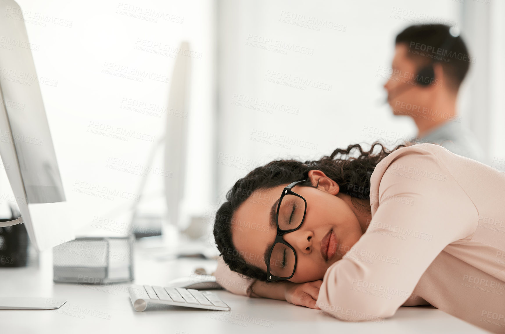 Buy stock photo Shot of a young female call center agent taking a nap at work