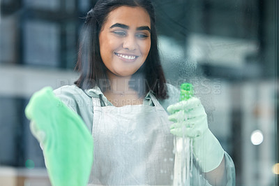 Buy stock photo Shot of a young woman cleaning her windows